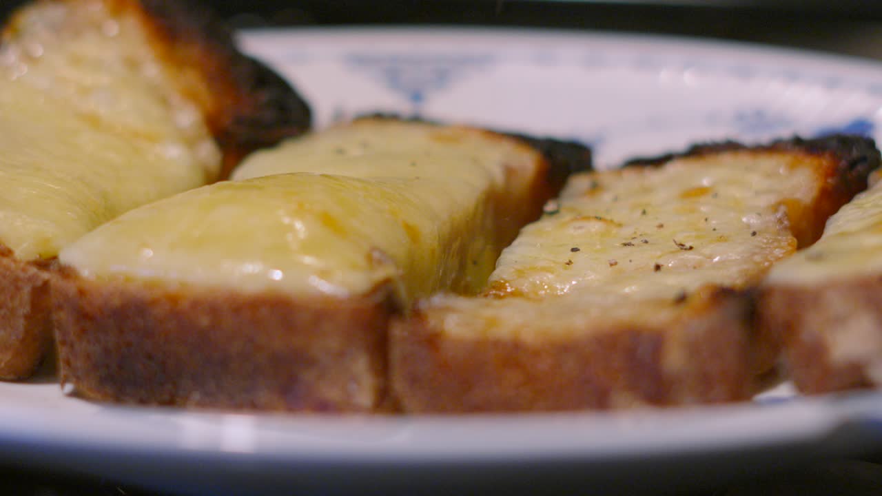Pepper Granules Falling on Melted Cheese on Homemade Baked Bread Toast in Slow Motion. Lunch Food Footage 4K.
