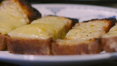 Pepper Granules Falling on Melted Cheese on Homemade Baked Bread Toast in Slow Motion. Lunch Food Footage 4K.
