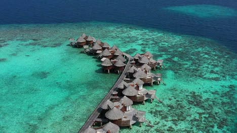 aerial view of beautiful maldives island over water villa bungalows in turquoise lagoon near the white sand beach in the sunny day 4k