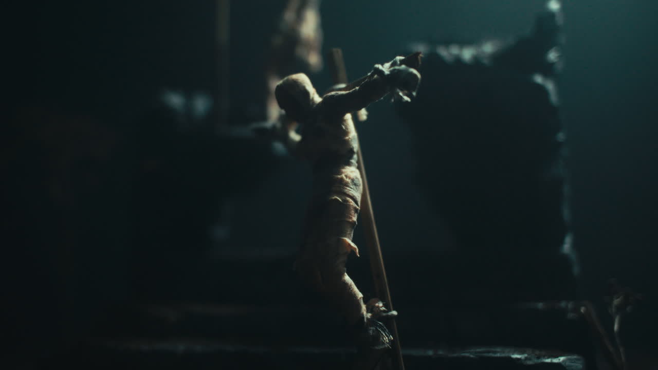 Miniature mummified dolls hanging on the gallows at night