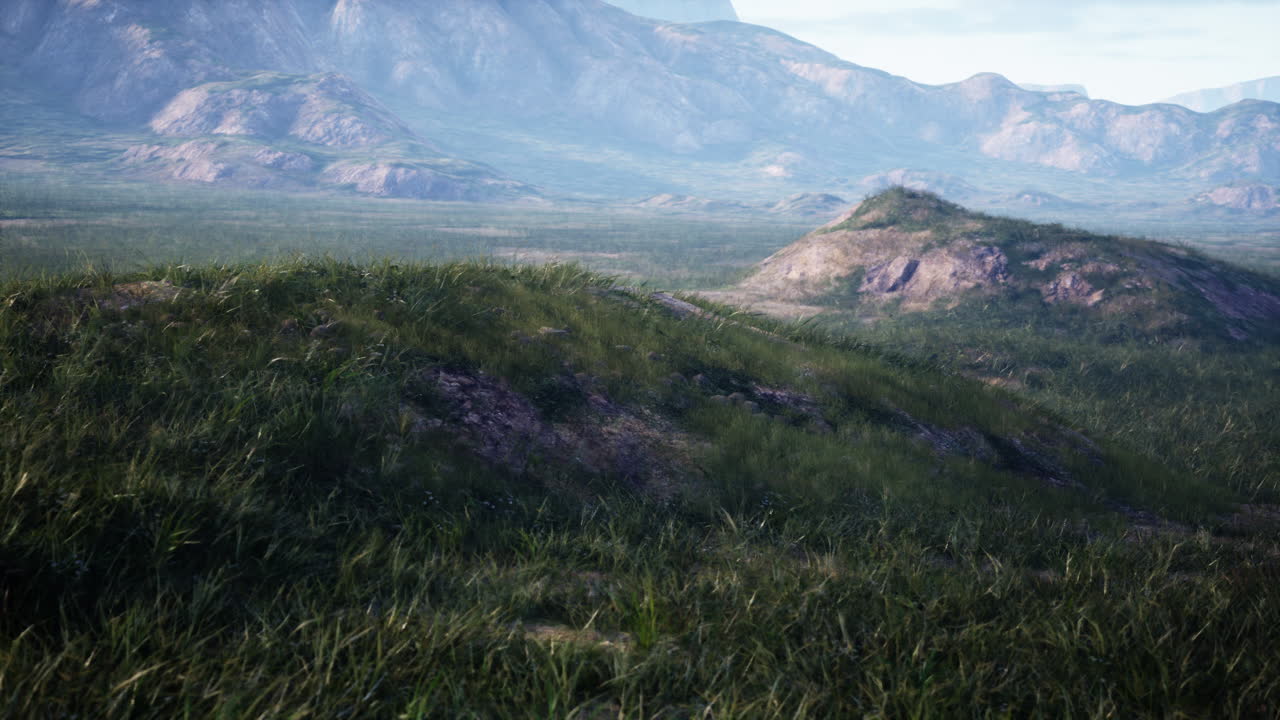 мирный горный пейзаж с зеленой травой и голубым небом