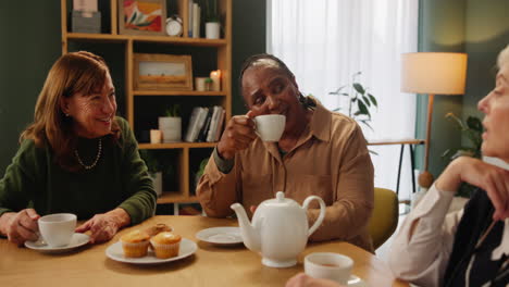 three senior women having tea and muffins