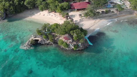 cinematic aerial drone shot of iconic resort in philippines island, with crystal clear blue water, white sand and cliff jumping on hot sunny summer day-1