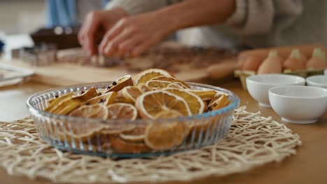 Getrocknete-Zitronen-Im-Vordergrund-Und-Menschliche-Hände-Nicht-Wiederzuerkennender-Menschen,-Die-Lebkuchenplätzchen-Zubereiten.