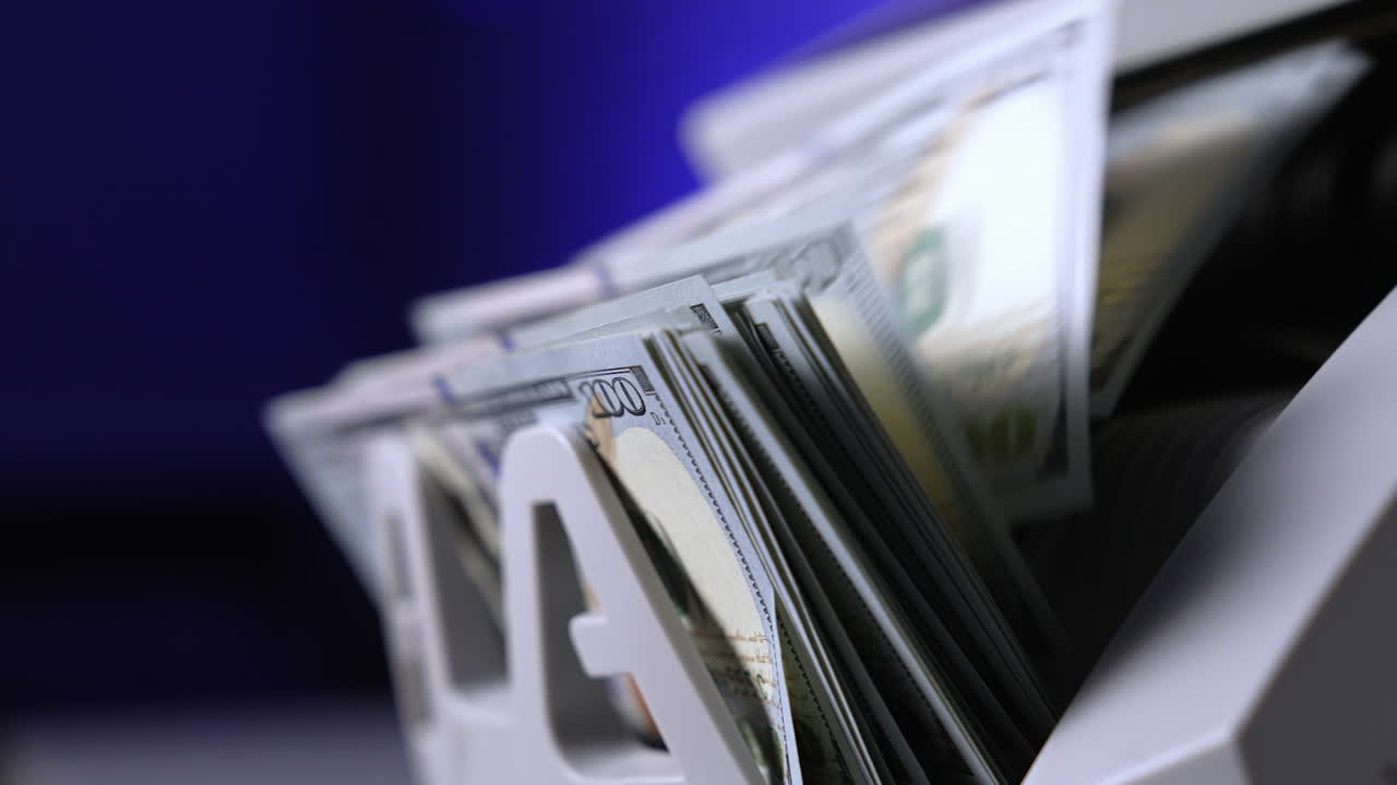 Currency counting machine counts 100 dollar bills. Cash bill counter money machine. Automatic mechanism for bank financial operations. Finance concept. Close-up.