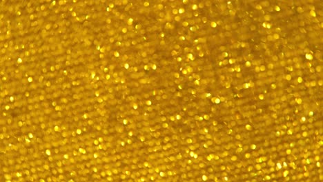 abstract shiny glitter and sparkles 4k video background golden or yellow glitter background with sparkling gems texture. gold shimmering light, sequins sparks and glittering glow foil background.