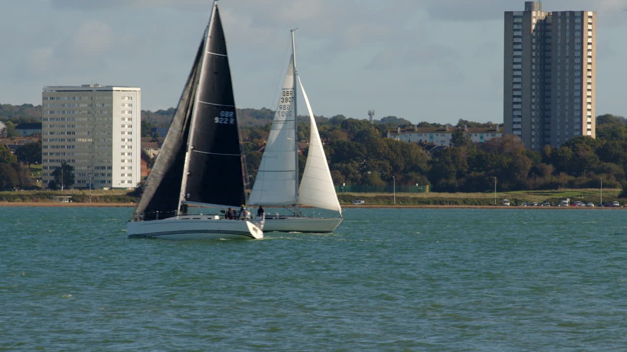 dos veleros se cruzan en el solent en southampton con weston en el fondo