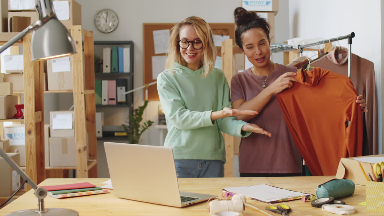dos mujeres discutiendo diseños de moda durante una reunión de negocios en línea