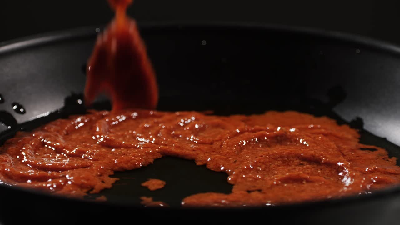 Cooking tomato sauce close-up. Classic homemade Italian tomato sauce for pasta and pizza in the pan. Chef cooking traditional Italian food. High quality 4k footage