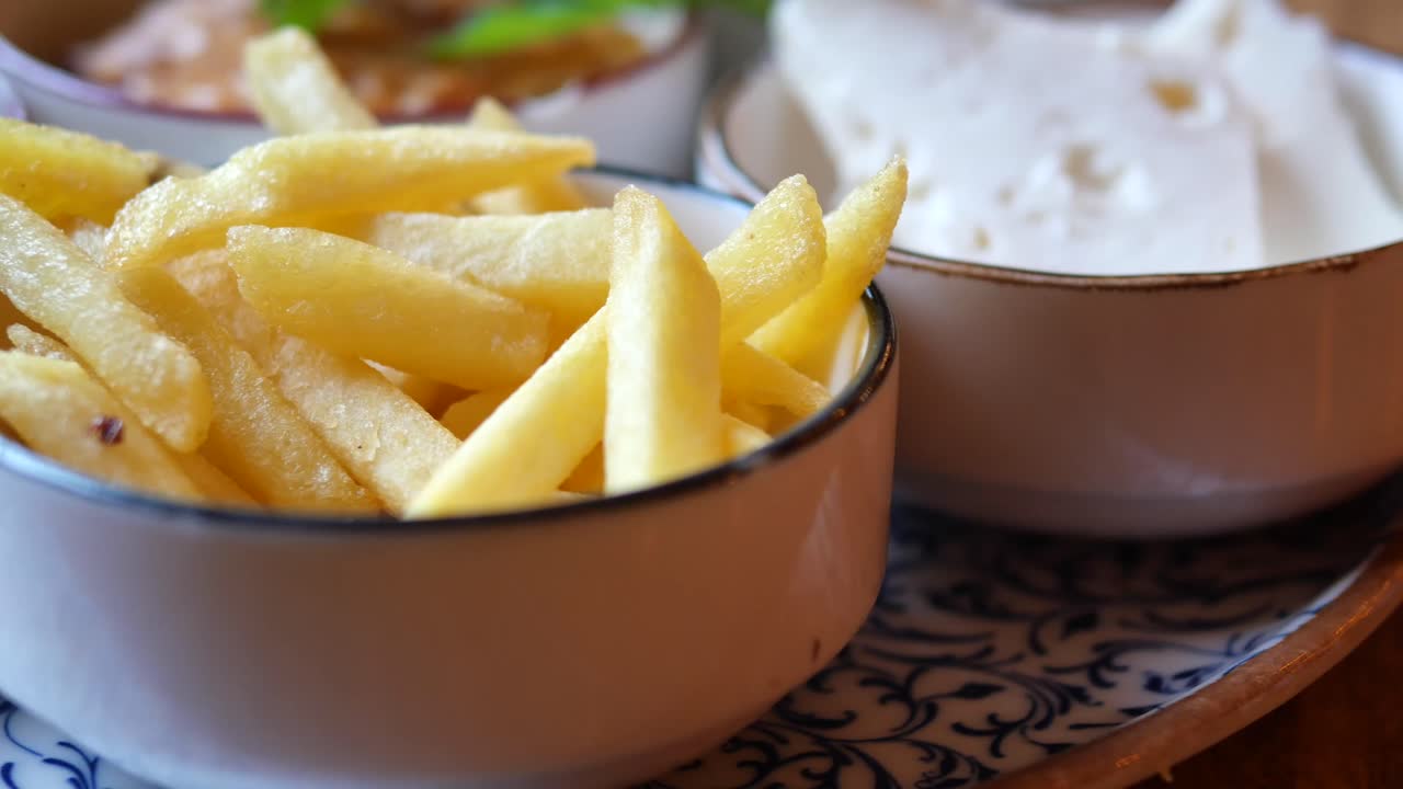 Golden French Fries Served in a Bowl with Side Dishes