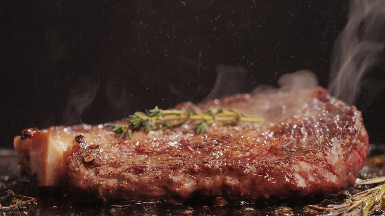 Fresh marbled beef with pepper, salt and rosemary close-up macro. Cooking juicy steak on grill with oil. Premium organic wagyu meat. High quality 4k footage