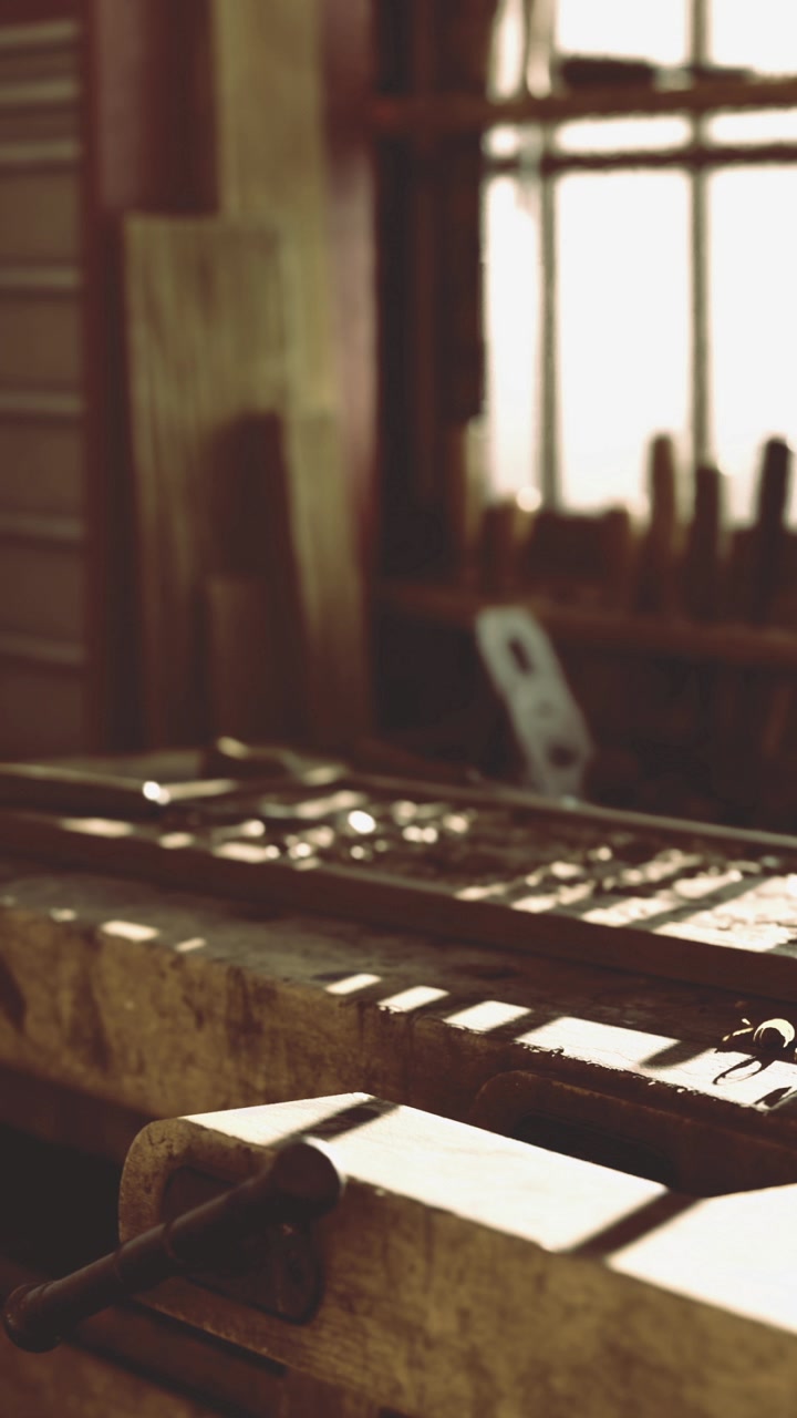 Woodworking tools and equipment are arranged on a bench in a workshop