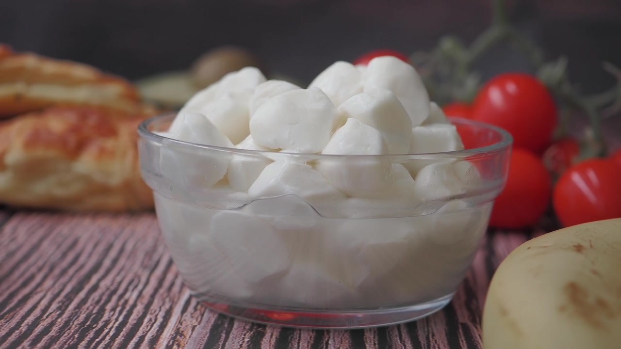 Bol de boules de mozzarella fraîche sur une table en bois