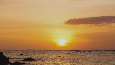 timelapse de una puesta de sol dorada en el extranjero. puesta de sol naranja redonda en el agua en la noche de verano. paisaje naturaleza amanecer fondo. imágenes b rollo de sol. cielo amarillo puesta de sol. hermoso océano tranquilo.