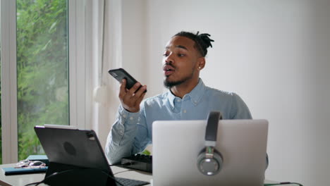 Friendly-freelancer-chatting-smartphone-closeup.-Modern-african-man-using-phone