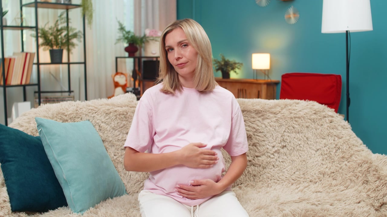 Těhotná žena ukazuje palcem dolů gesto nesouhlasu, vyjadřuje negativní recenzi, nespokojenost a odmítnutí zpětné vazby