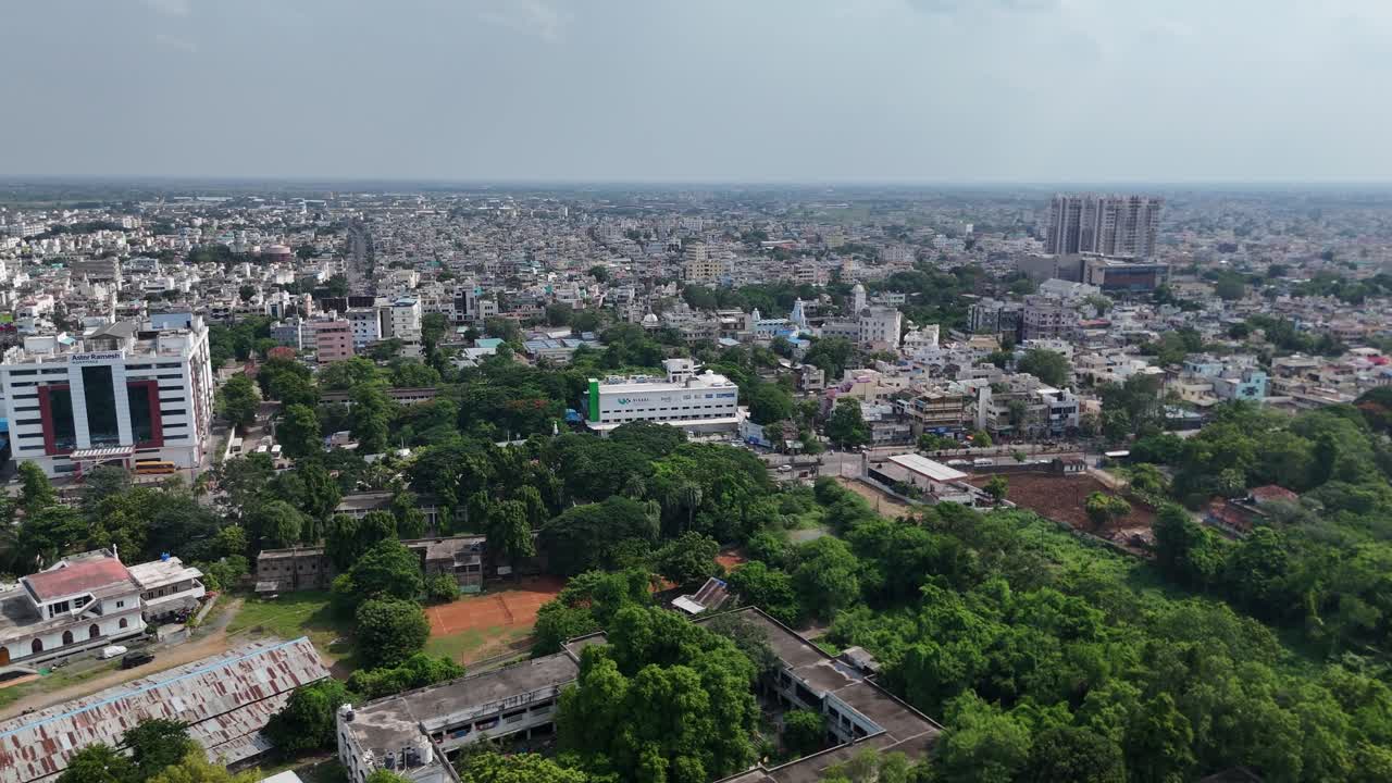 Affascinante Ripresa con Drone della Città di Vijayawada, dove le Trafficate Strade Cittadine Convergono verso una Serena Collina sullo Sfondo