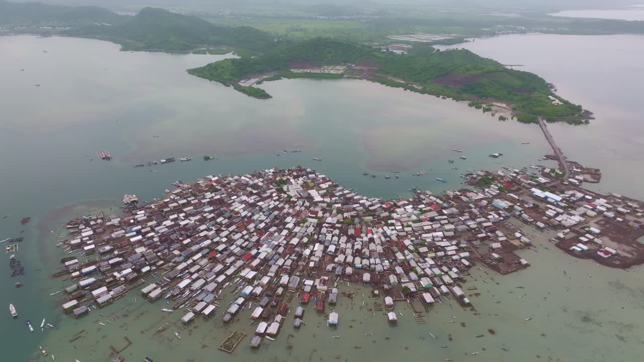 Komunitas nelayan yang ramai dengan kapal dan pondok pesisir, Sumbawa, Indonesia
