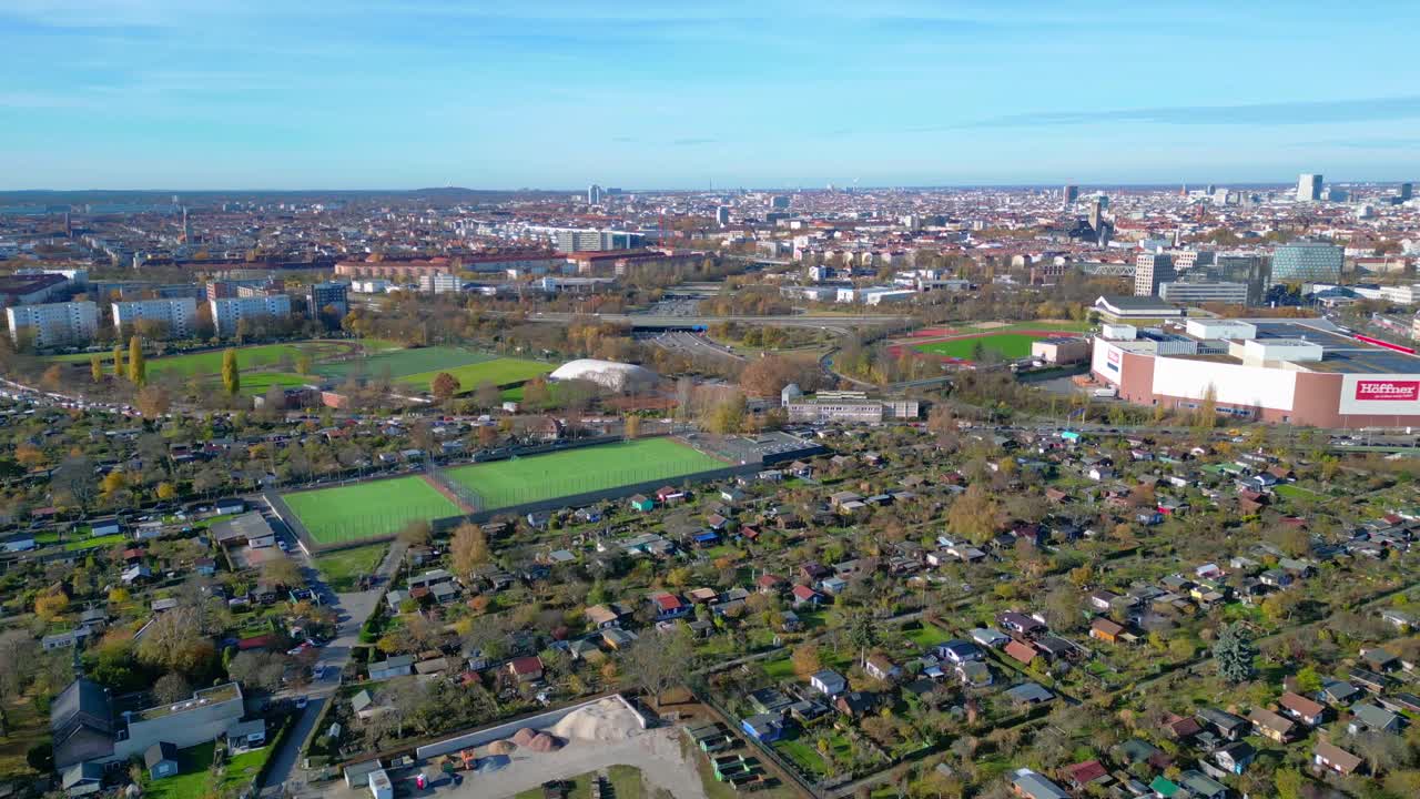 Berlin urban landscape with a large allotment garden area, sports soccer fields, football pitches and city infrastructure. Lovely aerial view flight panorama overview drone