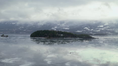 exuberante isla rodeada de agua helada del lago steinsfjorden en vik, noruega durante la temporada de invierno