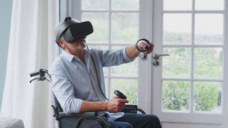 hombre discapacitado en silla de ruedas en casa con auriculares de realidad virtual sosteniendo controladores de juegos