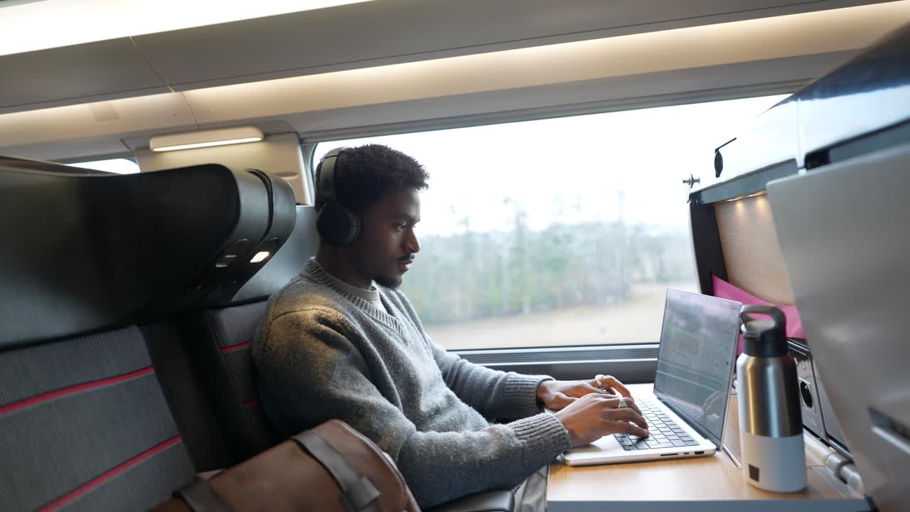 Man working on laptop on a train