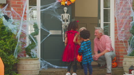 grandchildren dressing up and visiting grandparent's house trick or treating on halloween