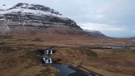 Aerial-shot-of-the-waterfalls-in-front-of-Kirkjufell,-Iceland