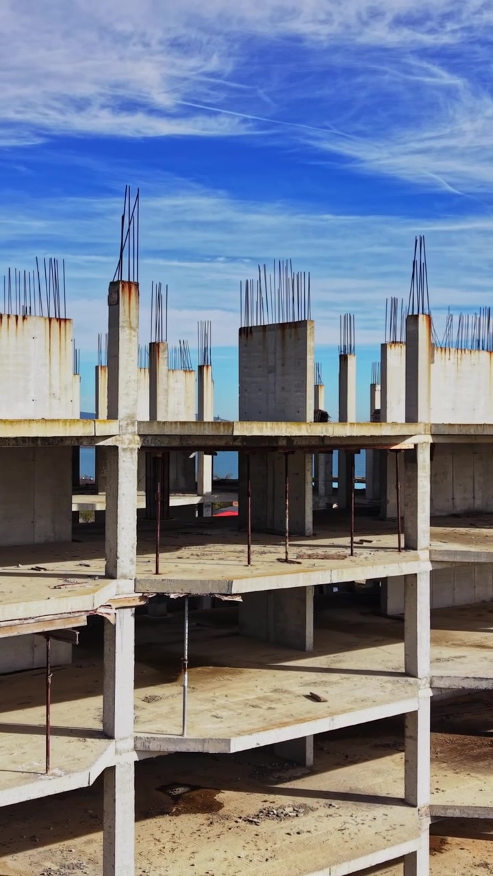 Construction site near coastline shows unfinished building in daylight