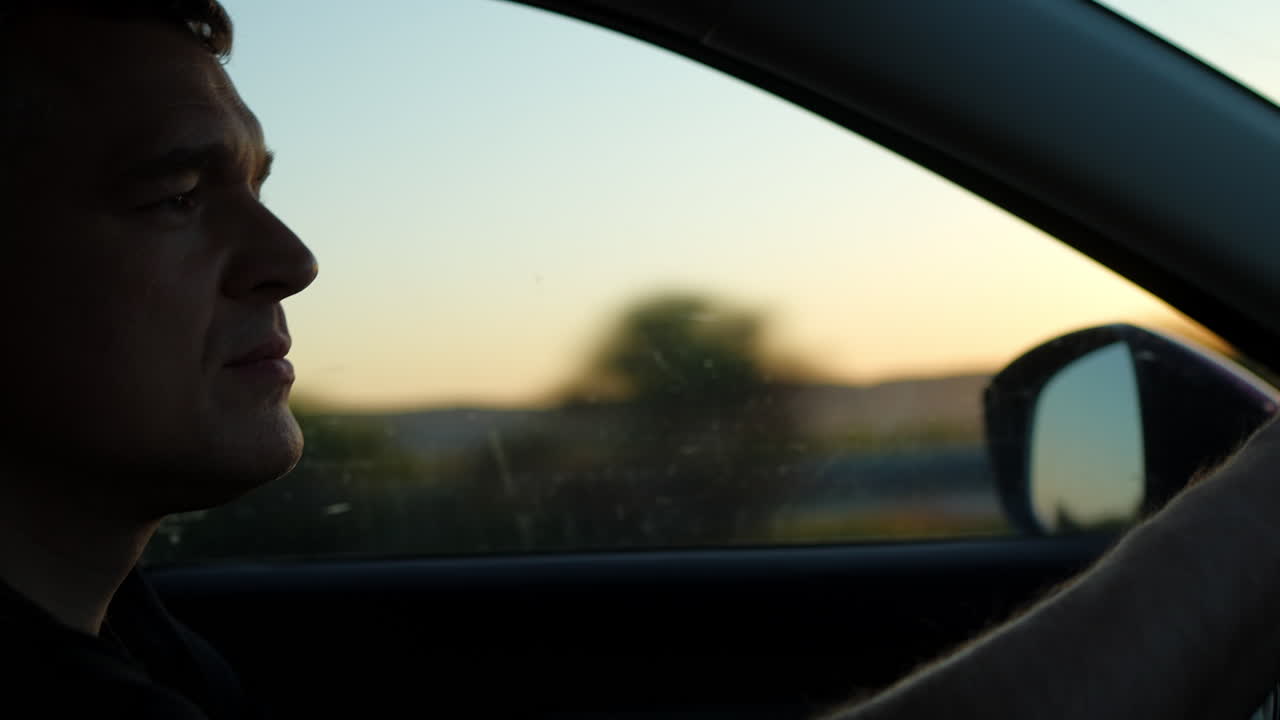 Man driving at sunset