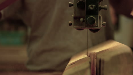 Band-saw-cutting-through-piece-of-wood---close-up---slow-motion