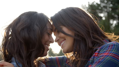 lesbian couple embrace touching noses, eyes closed, close up