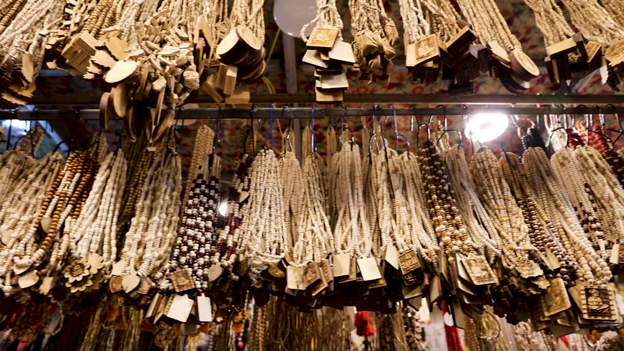 guirnalda espiritual de oración con malas hierbas tulsi y colgantes tallados exhibidos en el bazar indio