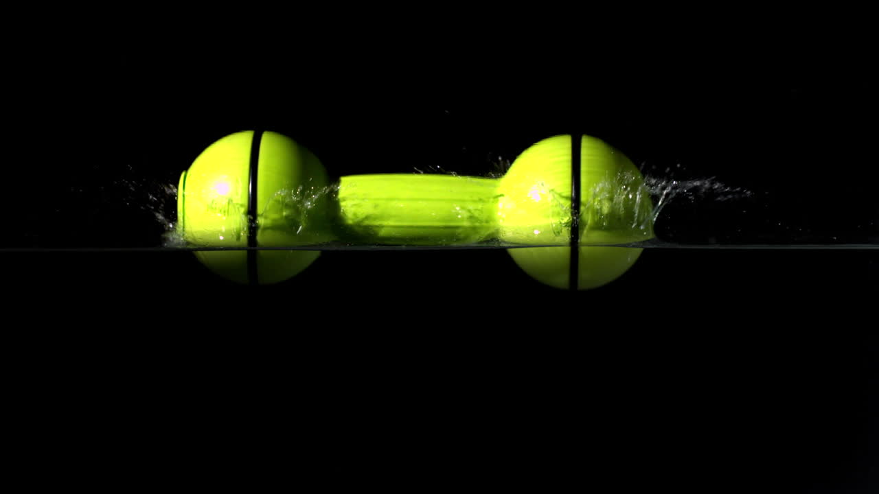 물 속으로 떨어지는 노란색 덤벨