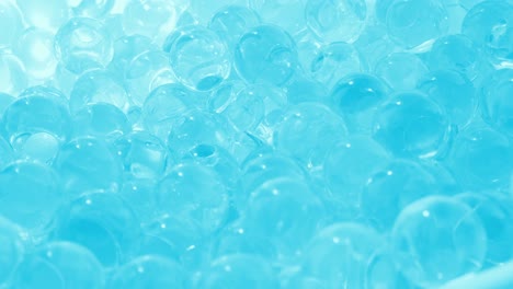 bolas de vidrio de vidrio azulado. rotación suave. hidrogel y cuentas. video macro