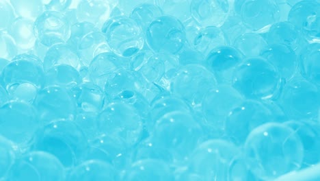 glass balls of bluish glass. smooth rotation. hydrogel and beads. macro video