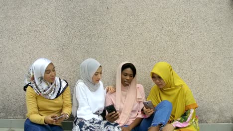 college girls in hijab using smartphone