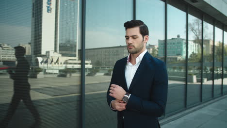 Portrait-man-checking-time-on-watch.-Businessman-walking-in-suit-at-street