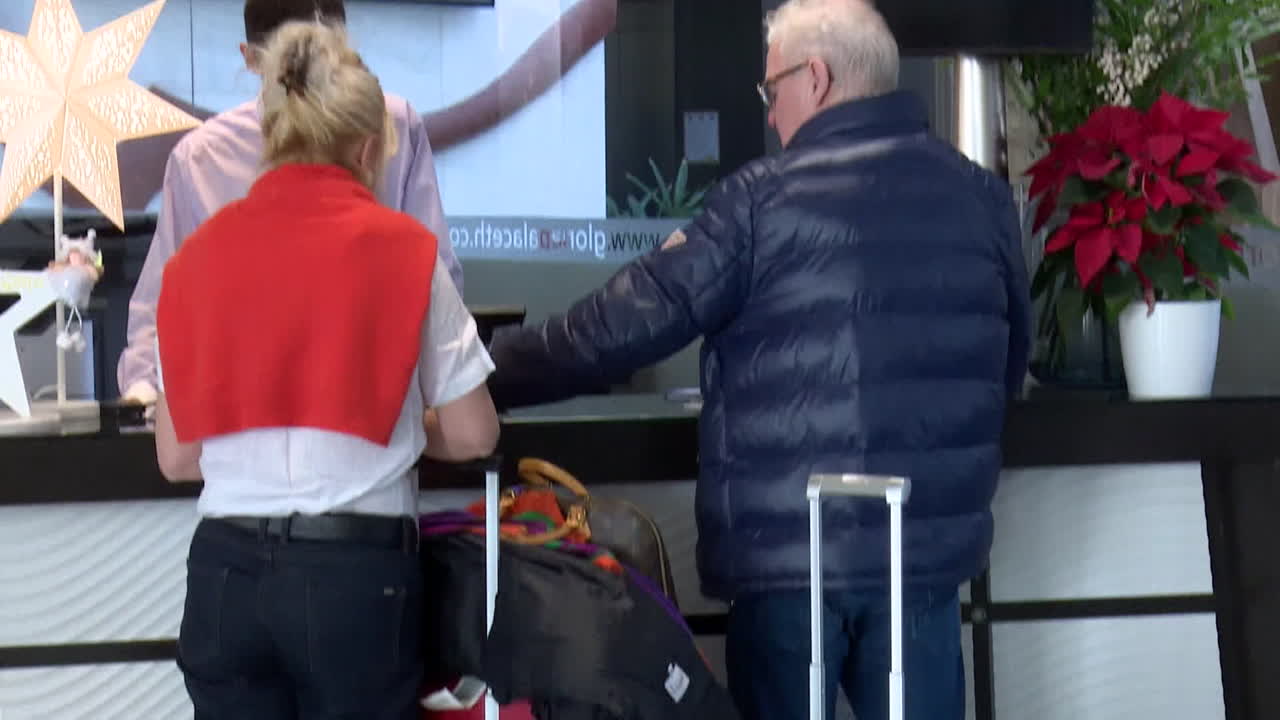 People waiting at the hotel/airport reception desk with luggage