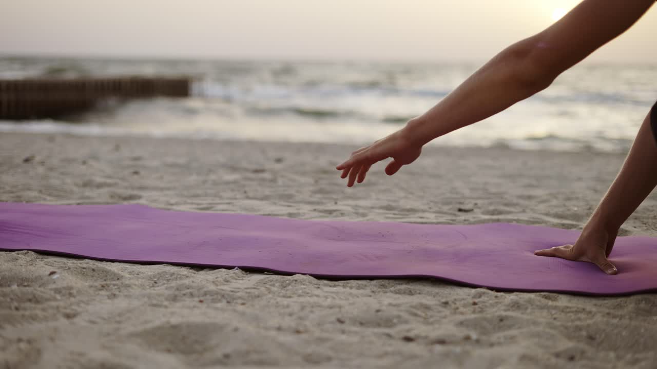 un joven coloca una alfombra deportiva y se prepara para una clase de yoga durante el amanecer del hijo. tiempo de ocio, recreación. primer plano