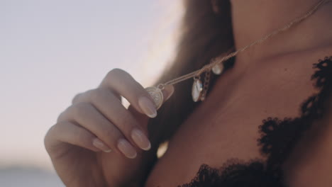 beautiful woman holding her pendant decoration sunset close up shot