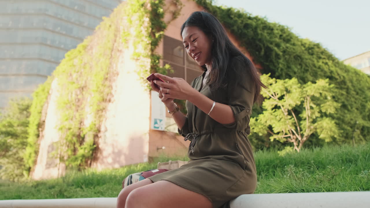 Woman using phone outdoors in an urban setting