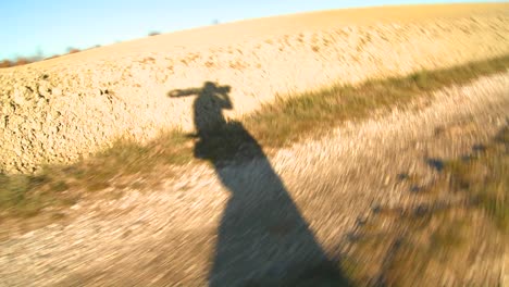 La-Sombra-De-Un-Cineasta-Caminando-Por-Un-Camino-De-Tierra