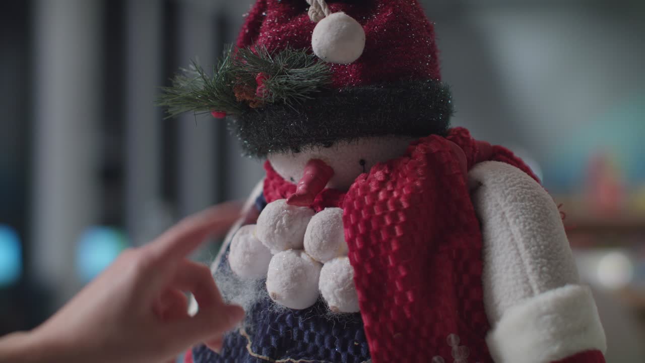 A Fun christmas stuffed snow man toy gets placed for the christmas holiday season.