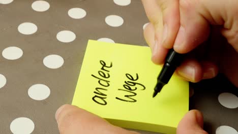 woman is writing "andere wege gegen" on a post-it