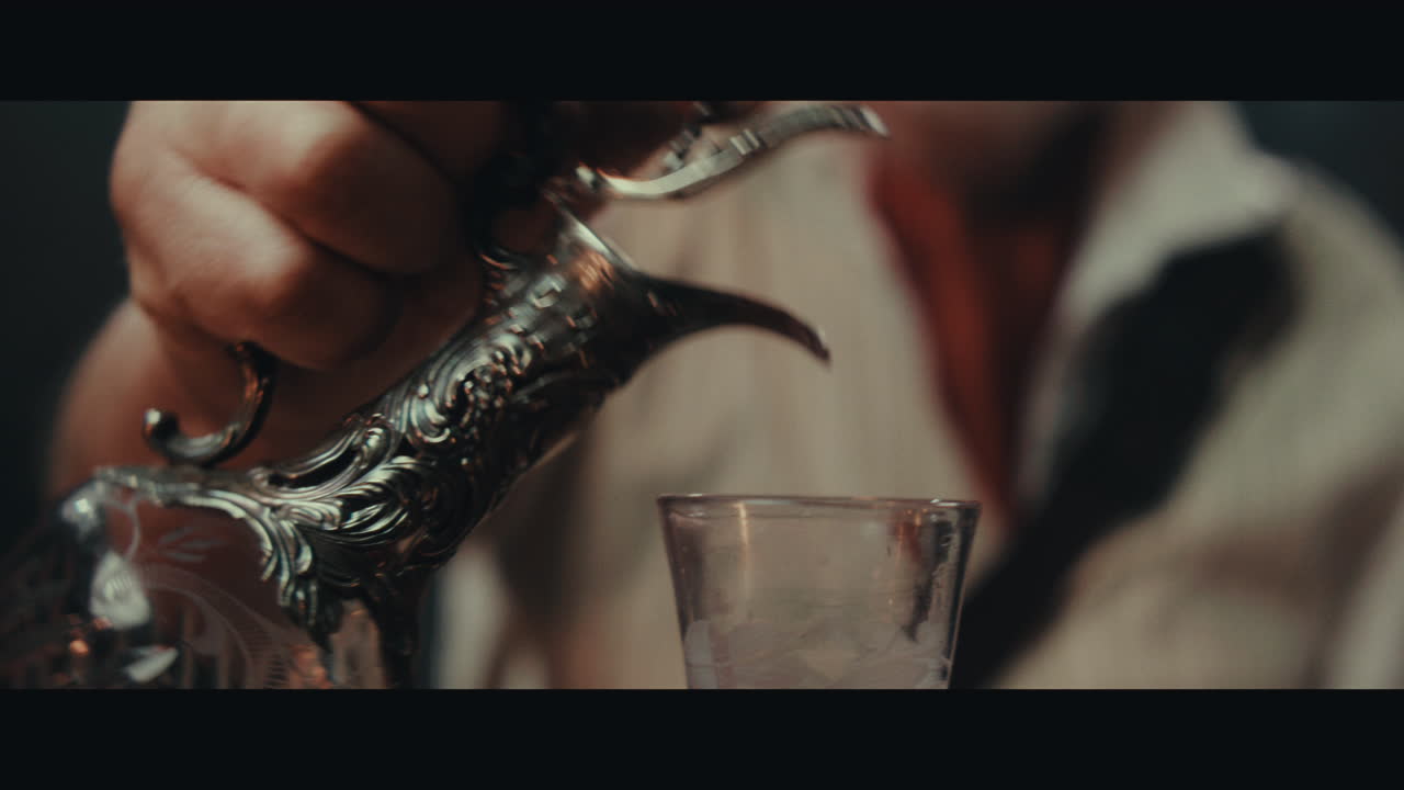 An old pirate eats and drinks inside the sailing ship cabin