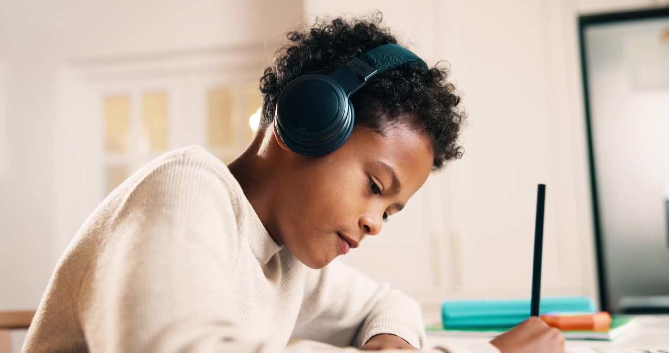 Young Boy Wearing Headphones Studying at Home