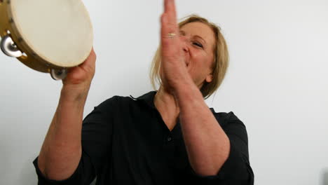 very happy woman playing the tambourine, shouting hey