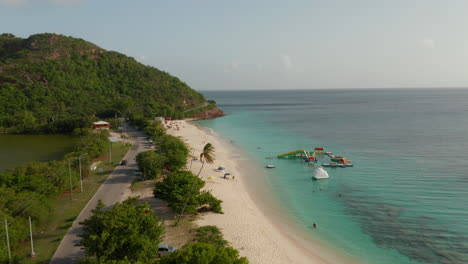 Vista-Aérea-Panorama-Panorámico-De-La-Parada-Del-Vehículo-Con-Tracción-En-Las-Cuatro-Ruedas-Junto-A-La-Playa-En-La-Costa-De-Antigua-Barbuda