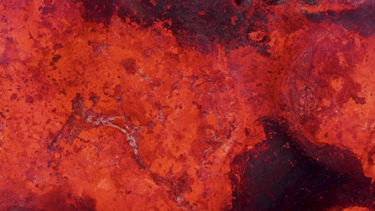 Close up of hot molten magma bubbling in volcano crater, top down
